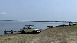 Тягачи лодочных прицепов на берегу Амура, жители села занимаются ловлей рыбы