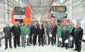 Электропоезд ЭС1 и электровоз 2ЭС7, а также рабочие завода во время посещения предприятия Владимиром Путиным